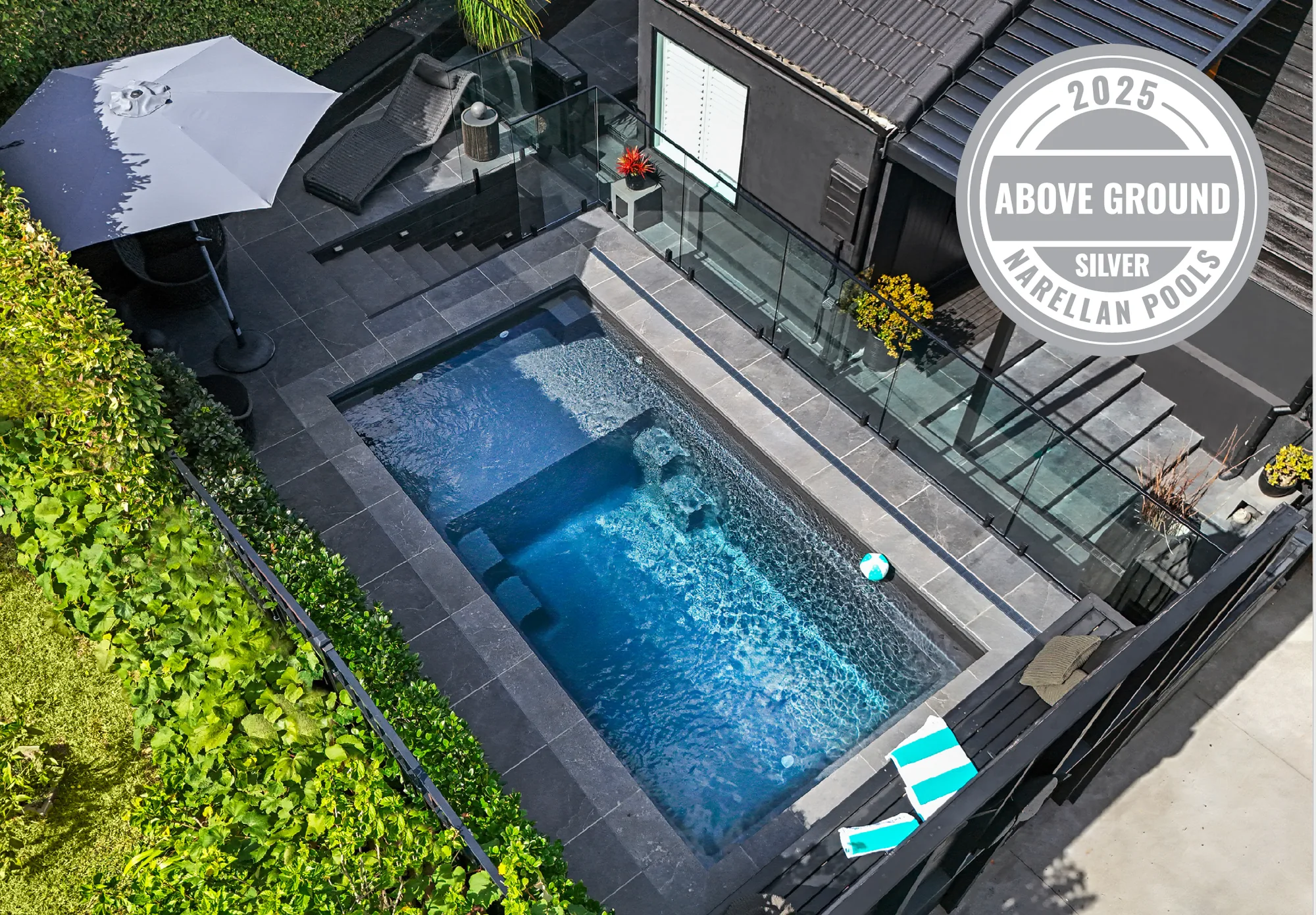 Aerial view of the Pt Chevalier designer plunge pool with dark stone-tiled surround by Tarara Tiling, Auckland — the project won Silver at the 2025 Narellan Pools Awards