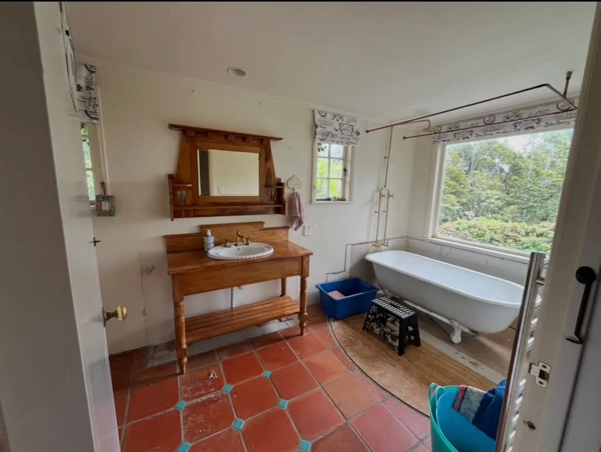 Waimauku villa bathroom before renovation — dated fittings and terracotta floor