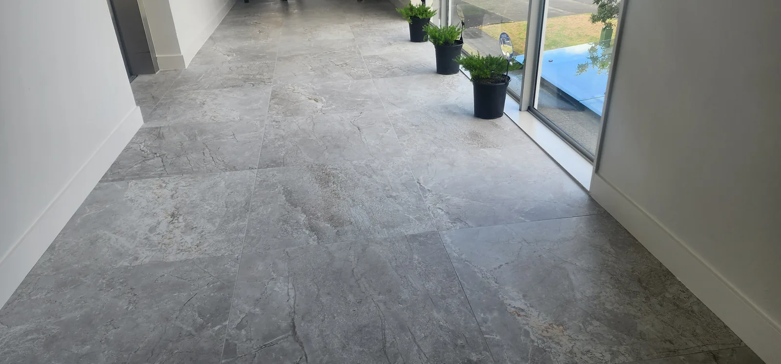 Stone-look porcelain floor tiling through a shared foyer of a three-level commercial office development in Henderson, West Auckland — by Tarara Tiling