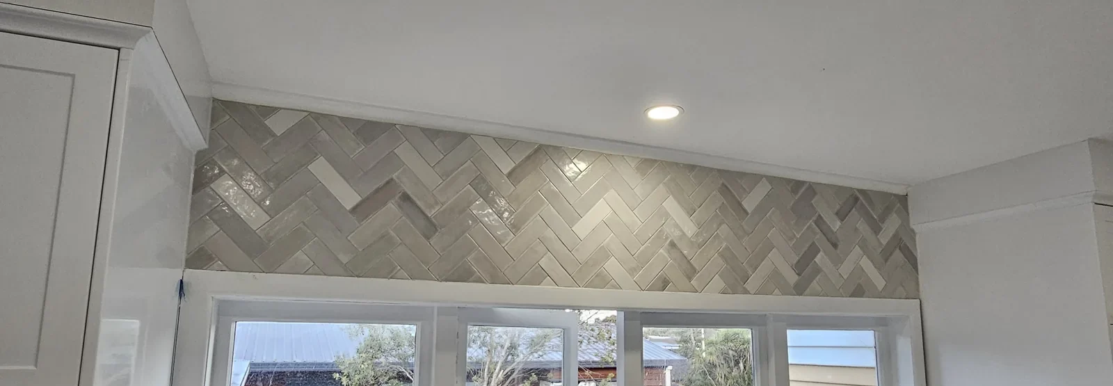 Tiled kitchen splashback with precise cuts around the benchtop in an Auckland kitchen by Tarara Tiling